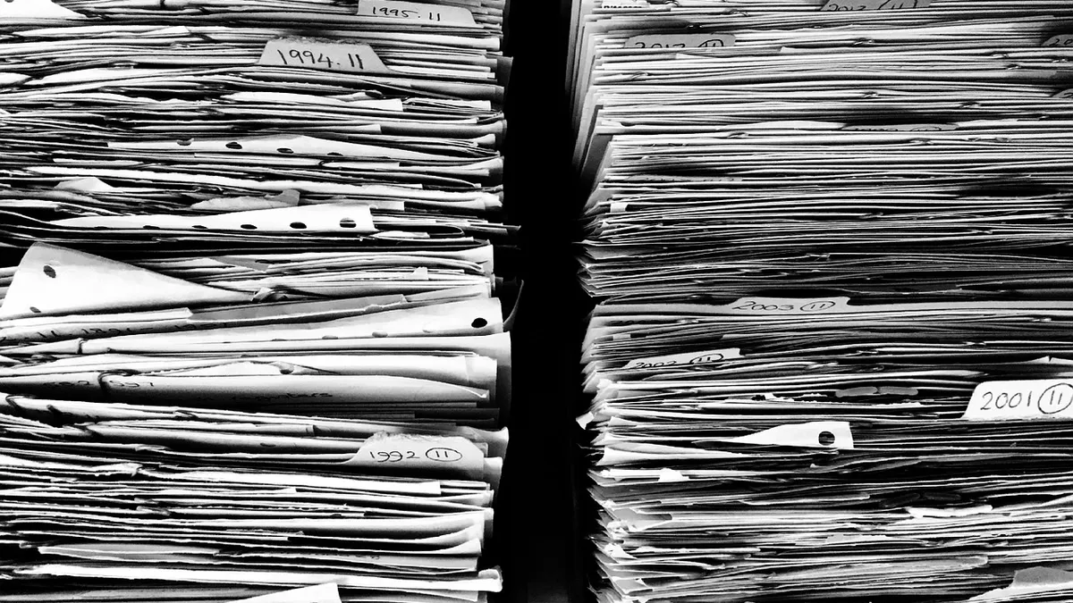 Tall stacks of paper files held in an office archive