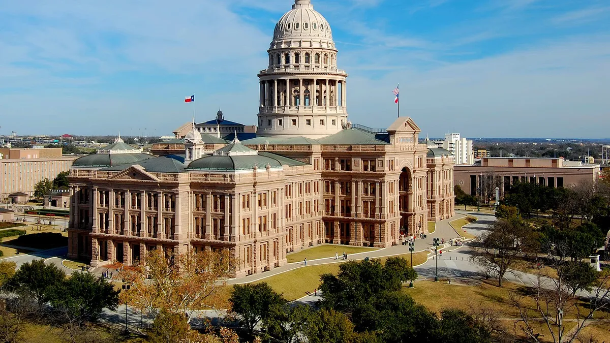 The Texas State Capitol in Austin, with its pink granite dome, under a blue sky